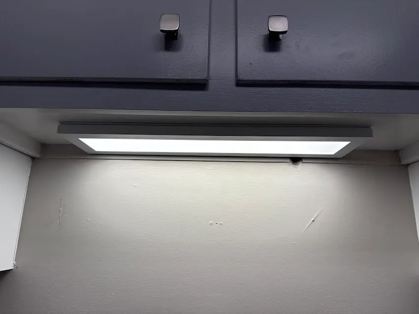 Under-cabinet light fixture installed above a kitchen work area